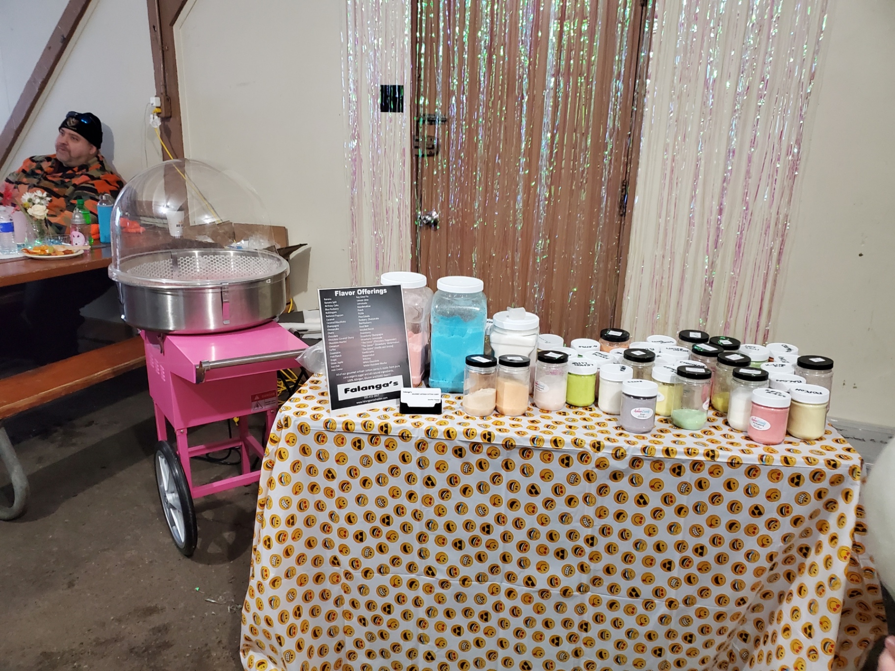 Falanga's flavor jars lined up on the booth table next to the cotton candy machine